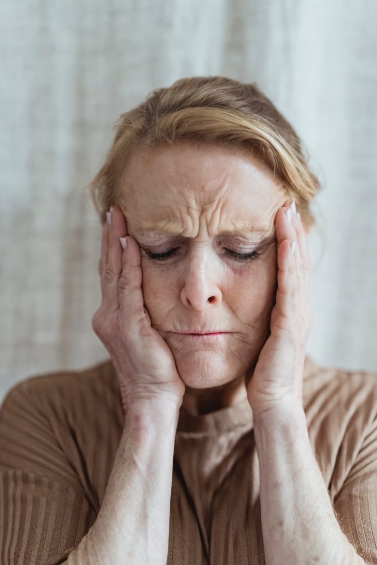 woman with head in hands showing how we deal with traumatic events and the effect on the body